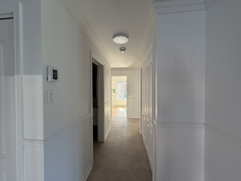Couloir avec sol en céramique et portes de rangement dans un appartement du TriEau à McMasterville.